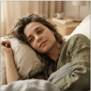 Woman resting in bed looking exhausted and fatigued.