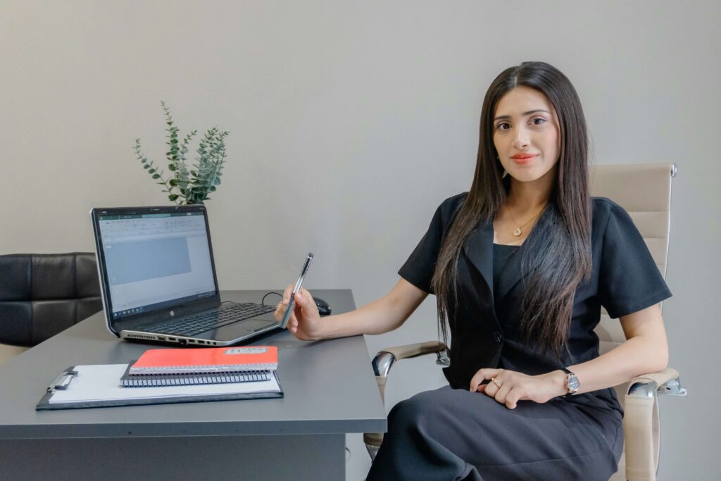 Nurse practitioner sitting at a desk in front of a laptop computer.